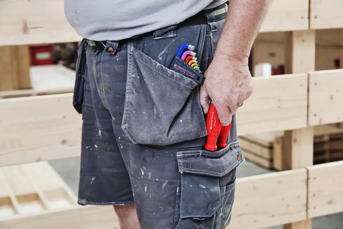 Tradesman with tools in work pocket
